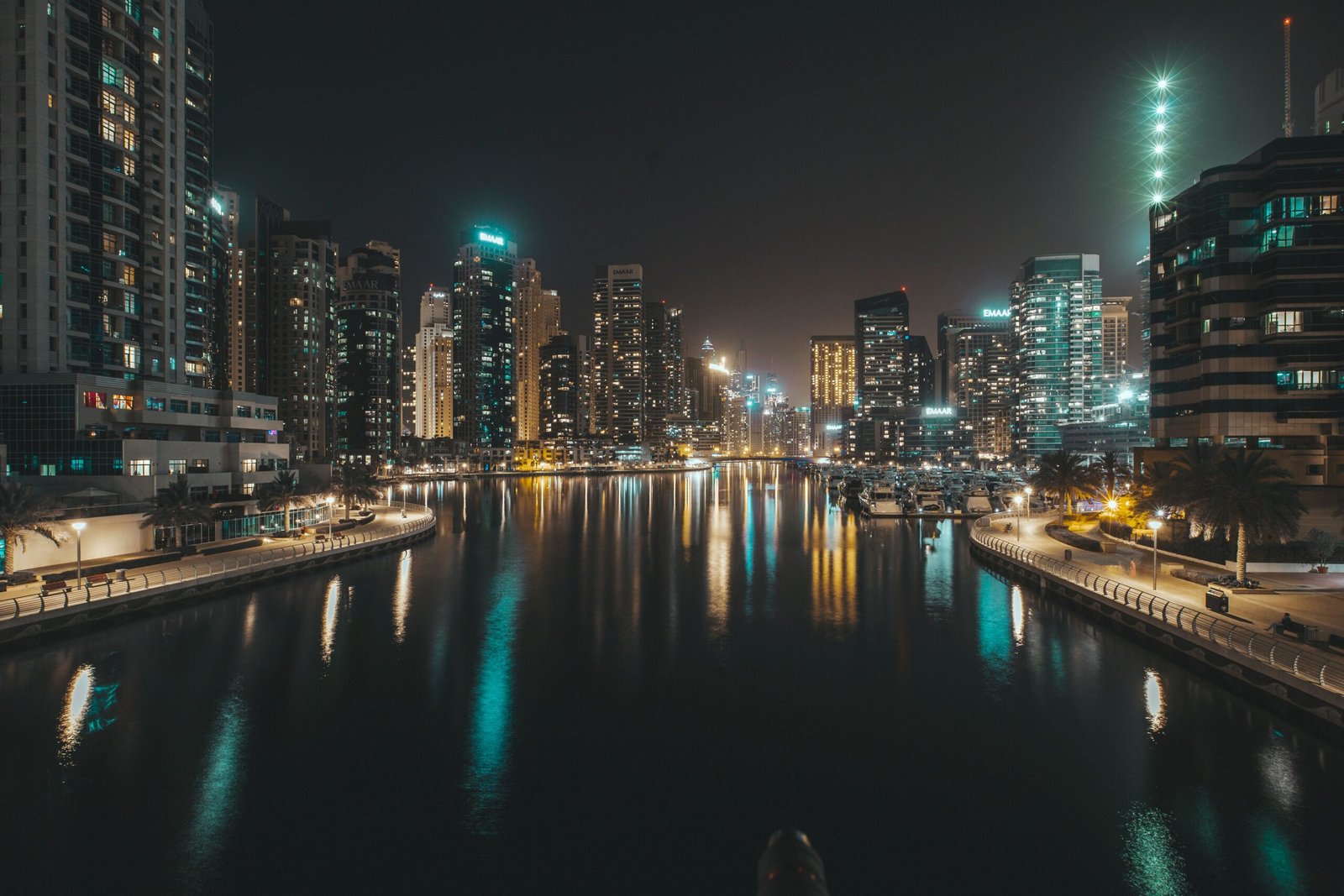 Explore the mesmerizing Dubai Marina skyline at night with illuminated high-rises and tranquil waters.